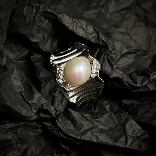 Pearl ring on crumpled black paper