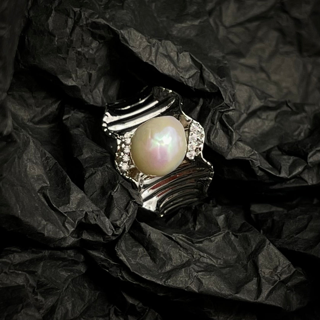Pearl ring on crumpled black paper