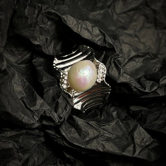 Pearl ring on crumpled black paper